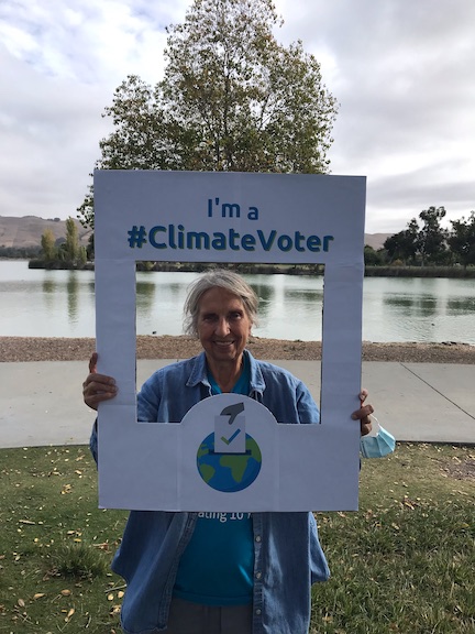Photo of Irm holding climate voter sign