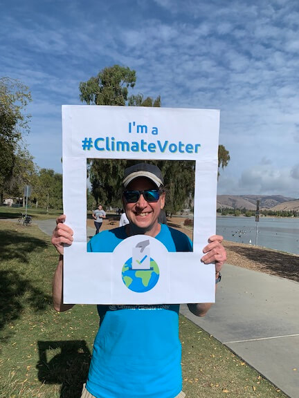 Photo of Karl holding climate voter sign