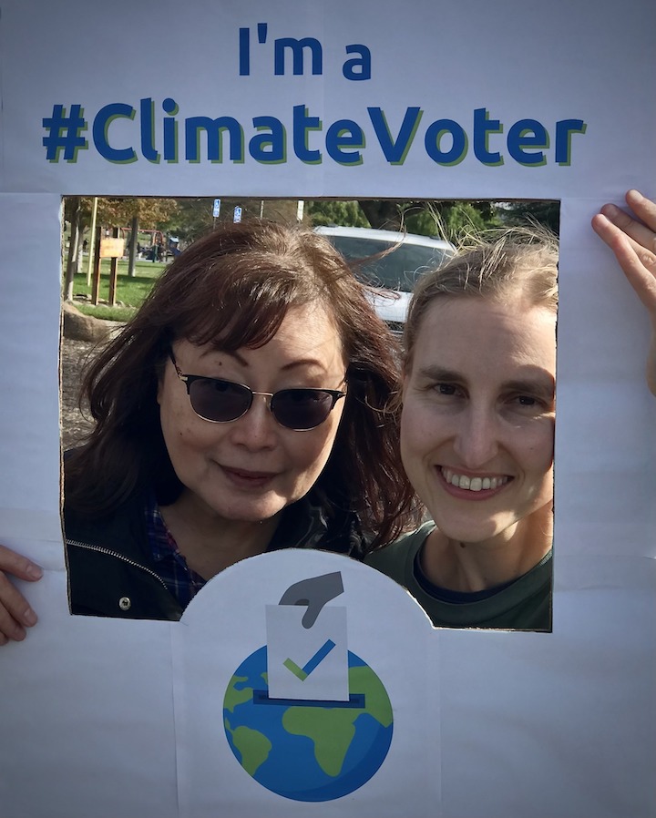 Photo of Mary and Lisa holding climate voter sign