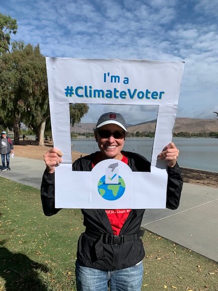 Photo of Paula holding climate voter sign